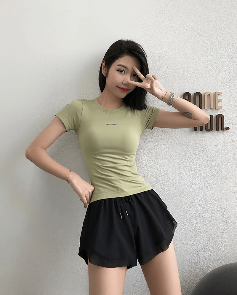 Woman wearing a breathable short sleeve fitness t-shirt in a cool pose. Ideal for yoga, running, quick-drying, anti-shrink gym wear.
